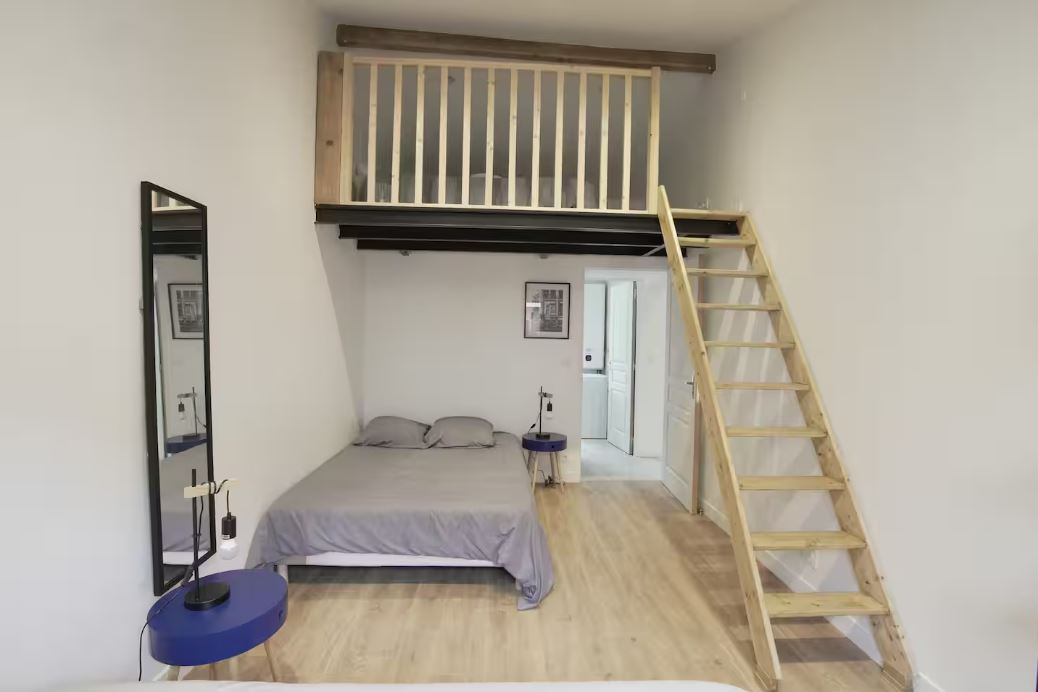 Chambre avec lit double et mezzanine accessible par escalier
