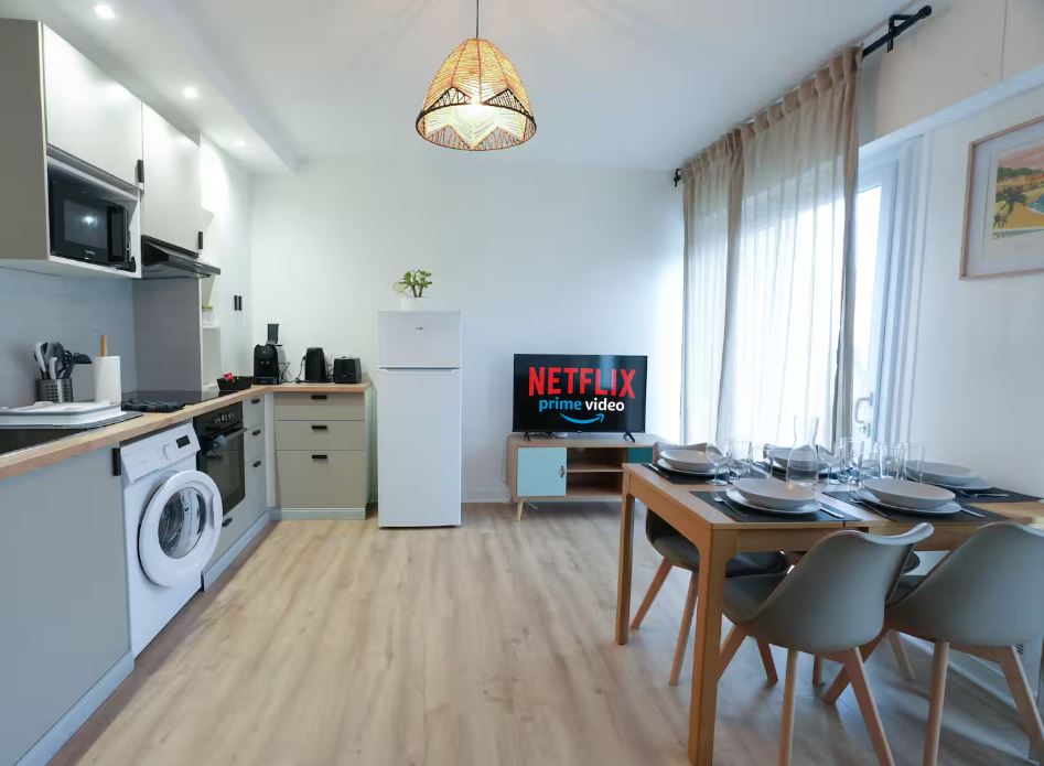 Cuisine équipée ouverte sur le coin repas et la télévision